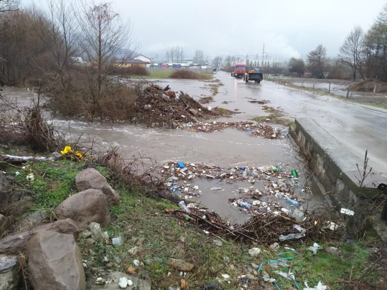 Река, затлачена от боклук и храсти, наводни път, склад и ниви